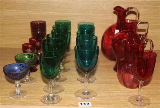A Cranberry jug and mixed coloured glassware
